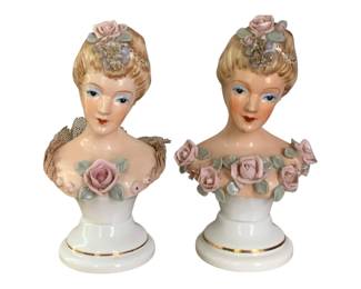 50 - 2 Occupied Japan Head Statues 7" Tall (Description): A pair of decorative head statues marked  Occupied Japan. These porcelain bust  figurines feature feminine forms with applied  floral accents and gilded base trim. Each  statue measures 7 inches tall.
