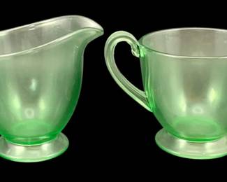 374 - Uranium Green Glass Creamer & Sugar Set (Description): A two-piece uranium glass creamer and sugar  set. The set features the characteristic  green translucent glow typical of uranium  glass. Measures 3 inches by 5.5 inches.