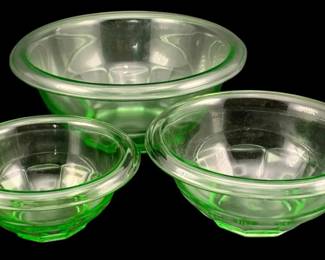 395 - 3  Anchor Hocking Uranium Green Glass Bowls (Description): A three-piece set of Anchor Hocking uranium  glass mixing bowls. The bowls feature the  characteristic green glow of uranium glass  and nest together for convenient storage.  Largest bowl measures 3.5" x 8.5".