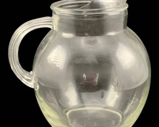 351 - Glass Pitcher 9"x8"x6.5" (Description): Glass pitcher with a round body, ribbed  handle, and pour spout lid. Measures 9 inches  by 8 inches by 6.5 inches.