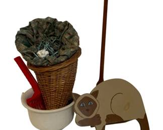 740 - Assorted Items (Description): A mixed lot of assorted home decor items  including a wicker basket with fabric liner,  a ceramic bowl with red utensil, a wooden  paper towel holder or stand, and a decorative  painted wooden cat figure in Siamese coloring.
