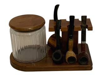 754 - Tobacco Stand w/ Jar & 4 Pipes 6"x10"x5.5" (Description): A tobacco stand featuring a glass jar with  wooden lid and a rack holding four pipes. The  wooden stand measures 6 inches by 10 inches  by 5.5 inches.