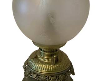 225 - Electrified Oil Lamp 22" (Description): Electrified oil lamp featuring an ornate  brass base with decorative scrollwork and a  frosted glass globe shade with clear glass  chimney. Measures 22 inches tall. Used as is electric/electronic/mechanical item. No guarantee all components, untested.