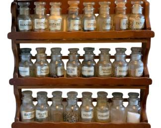 348 - Vintage Spice Rack 15"x15"x2.25" (Description): Wooden spice rack with three tiers, complete  with glass spice jars featuring labeled  stoppers. The rack measures 15 inches by 15  inches by 2.25 inches.