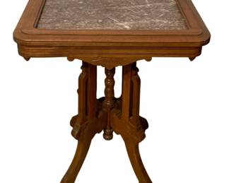 774 - Marble Top Table 30"x24"x18" (Description): Marble top table featuring a decorative  carved wood base with turned center spindle  and four splayed legs. Measures 30 inches  tall by 24 inches wide by 18 inches deep.