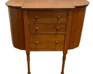 629 - Antique Sewing Stand 30"x28.5"x14.25" (Description): Antique sewing stand featuring three drawers  with wooden knob pulls, curved side  compartments, and turned legs. Measures 30  inches high by 28.5 inches wide by 14.25  inches deep.