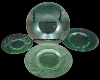 534 - 4 Uranium Green Glass Plates (Description): A lot of four uranium glass plates in  assorted patterns. One plate is chipped. Each  plate measures approximately 8.5 inches in  diameter.