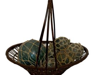741 - Basket w/ Glass Balls 16"x17"x10" (Description): A woven basket containing glass fishing  floats with rope netting. The basket measures  16 inches by 17 inches by 10 inches.