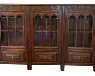 94 - Wood Cabinet Bookcase 48.5"x74.5"x12" (Description): Wood cabinet bookcase featuring glass-fronted  doors with arched detailing and lower  drawers with brass hardware. Measures 48.5  inches high by 74.5 inches wide by 12 inches  deep.