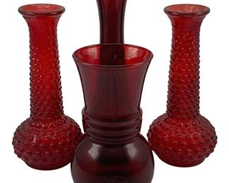 524 - 4 Red Glass Vases 9.25" (Description): A collection of four red glass vases  featuring varied styles. The lot includes two  hobnail pattern bud vases with bulbous bases  and elongated necks, along with two smooth  glass vases with different silhouettes. Tallest measures 9.25 inches.