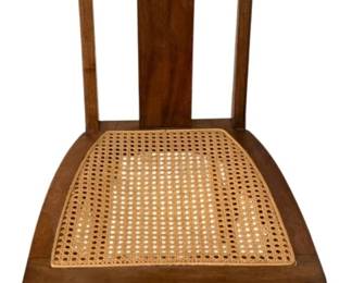 603 - Vintage Wood Rocker w/ Cane Seat 34"x17"x26" (Description): Wooden rocking chair featuring a cane seat.  The rocker has a carved decorative detail at  the top of the backrest and curved rockers at  the base. Measures 34 inches high by 17  inches wide by 26 inches deep.