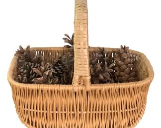46 - Basket w/ Pinecones 10"x11.5"x6" (Description): A woven basket filled with pinecones. The  basket measures 10 inches by 11.5 inches by 6  inches.