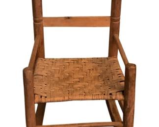 143 - Child's Antique Rocker w/ woven seat  20"x13"x19" (Description): Antique wooden rocking chair featuring a  ladder back design with turned posts topped  with ball finials. The seat is woven in a  traditional splint pattern. Measures 20  inches by 13 inches by 19 inches.