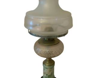 217 - Oil Lamp 21" (Description): Oil lamp measuring 21 inches in height.  Features a frosted glass shade with ruffled  edge, decorative pressed glass font,  hand-painted floral porcelain stem, and dark  base.