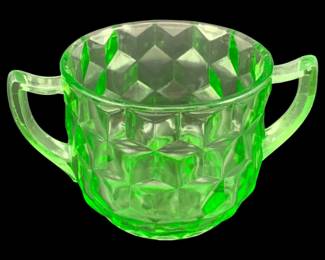535 - Uranium Green Glass sugar bowl 3"x5.5" (Description): Uranium glass creamer featuring two handles  and a decorative geometric pattern. This  piece exhibits the characteristic green glow  associated with uranium glass. Measures 3" x  5.5".