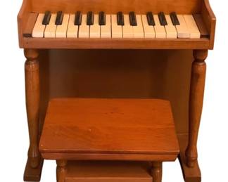 144 - Vintage Child's Musical Piano w/ Bench (Description): Vintage child's musical piano with matching  bench. The piano features turned legs and a  classic upright design in warm wood tones.  Measures 20" x 17" x 10.5". Used as is electric/electronic/mechanical item. No guarantee all components, untested.