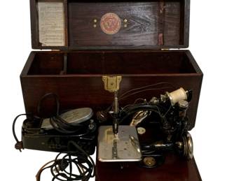 789 - Willcox & Gibbs Sewing Machine w/ case (Description): Willcox & Gibbs sewing machine housed in a  wooden carrying case with brass hardware  including corner protectors, handle, and  locking clasp with key on chain. The case  measures 11.5 inches by 22 inches by 11 inches. Used as is electric/electronic/mechanical  item. No guarantee all components, untested.