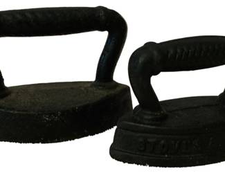 183 - 2 Cast Iron SAD Irons 3"x4.5" (Description): A pair of cast iron SAD irons, measuring 3  inches by 4.5 inches. These antique flat  irons were traditionally heated on a stove  and used for pressing clothes. One iron  features embossed text on its base.