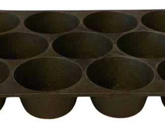 239 - Cast Iron Muffin Pan #8 11.5"x11"x7.75" (Description): Cast iron muffin pan marked #8, featuring  twelve cups with handle cutouts on each end  for easy lifting. Measures 11.5 inches tall  by 11 inches long by 7.75 inches wide.