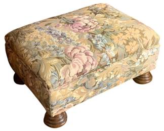 36 - Vintage Ottoman 11"x 22"x 16" (Description): An upholstered ottoman featuring floral  tapestry fabric in muted tones of pink, blue,  olive, and cream. The piece rests on turned  wooden bun feet. Measures 11 inches by 22  inches by 16 inches.