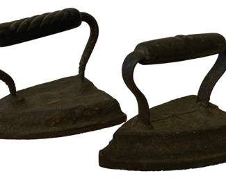189 - 2 SAD Irons 4.5"x6" (Description): A pair of antique SAD irons, also known as  sad irons or flat irons, used historically  for pressing clothing. These cast iron pieces  feature curved handles with twisted grip  details. Measurements: 4 1/2" x 6".