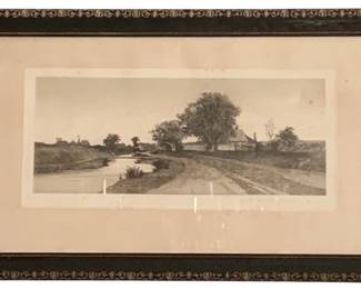 59 - Framed Print 19"x30.5" (Description): A framed print featuring a landscape scene.  The piece is presented in a decorative dark  frame with ornate detailing along the border.  Measures 19 inches by 30.5 inches.