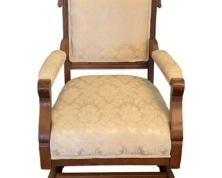124 - Antique Wood Rocker/Glider 37"x23"x26" (Description): Antique wood rocker/glider featuring carved  detailing on the crest rail and upholstered  seat, back, and armrests. Measures 37 inches  high by 23 inches wide by 26 inches deep.