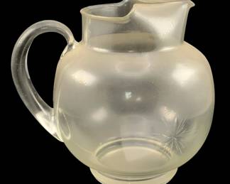 350 - Glass Pitcher 8.5"x9"x7" (Description): Glass pitcher with a rounded body, applied  handle, and shaped spout. Measures 8.5 inches  by 9 inches by 7 inches.