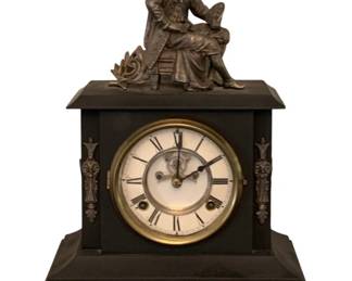607 - Antique Waterbury Mantle Clock 17"x14.5"x6" (Description): Antique mantle clock featuring a black case  with decorative bronze mounts and ornate claw  feet. The clock is topped with a figural  sculpture. The face displays Roman numerals  with a brass bezel. Used as is electric/electronic/mechanical  item. No guarantee all components, untested.  Measures 17 inches high by 14.5 inches wide  by 6 inches deep.