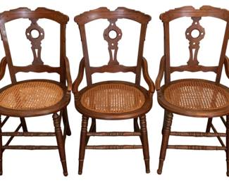 161 - 3 Antique Chairs 34"x18"x16.5" (Description): A set of three antique chairs featuring  carved wooden frames with decorative splat  backs and cane seats. Each chair measures 34  inches high by 18 inches wide by 16.5 inches  deep.