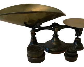 231 - Antique Scale w/ Weights 10"x21"x9" (Description): Antique balance scale with weights. The scale  features a cast iron base with brass pans -  one large scoop-style pan and one flat  circular pan. Includes a set of accompanying  weights. Measures 10 inches by 21 inches by 9 inches.