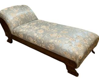 675 - Antique Chaise Lounge 26"x74"x26" (Description): Antique chaise lounge featuring a carved  wooden frame with decorative feet. The piece  is upholstered in a floral fabric. Measures  26 inches wide by 74 inches long by 26 inches  high.