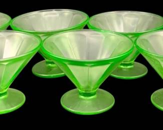 385 - 6 Uranium Green Glass Footed Sherbets 3"x4" (Description): These translucent green sherbets feature a  conical bowl shape with a short stem and  circular foot, characteristic of vintage  uranium or Vaseline glass. Each piece  measures 3 inches by 4 inches.