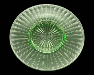 531 - Uranium Green Glass Plate 8" (Description): Uranium glass plate measuring 8 inches in  diameter. The plate features a radial ribbed  pattern extending from the center with a  starburst design in the base.