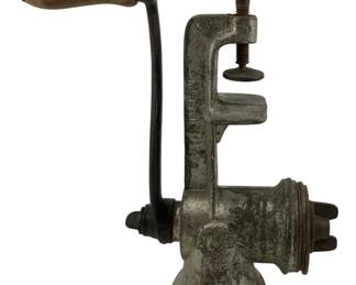 476 - Vintage Sausage Grinder 9.5"x6"x3.5" (Description): Antique sausage grinder featuring a  hand-crank mechanism with wooden handle and  table clamp mounting system. This cast metal  kitchen tool represents traditional food  preparation methods. Measures 9.5 inches by 6 inches by 3.5 inches.