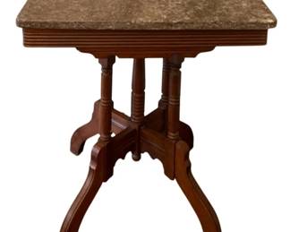 82 - Marble-top Table 29"x26"x18" (Description): A marble-top table featuring a warm brown  marble surface set upon a carved wooden base.  The base includes turned spindle supports  and curved splayed legs with decorative  carved details. Measures 29 inches high by 26 inches wide by 18 inches deep.