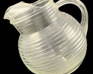 352 - Glass Ball Pitcher 6"x7"x6" (Description): Glass pitcher featuring a ribbed design with  a rounded body and curved handle. Measures 6  inches by 7 inches by 6 inches.