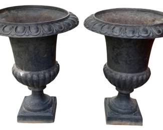 2 - 2 Cast Iron Planters 24"x19" (Description): A set of two cast iron planters in a classic  campana urn form. Each planter features  decorative detailing and rests on a square  pedestal base. Measurements are 24 inches  tall by 19 inches in diameter.