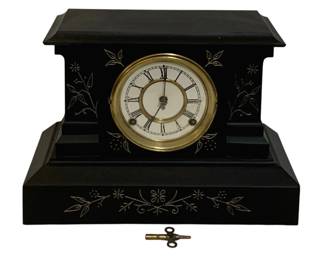 744 - Antique Mantle Clock w/ Key 10"x15"x6.5" (Description): Antique mantle clock with key. The clock  features a Roman numeral dial with brass  bezel and decorative incised floral designs  on the black case. Measures 10 inches high by  15 inches wide by 6.5 inches deep. Used as is electric/electronic/mechanical  item. No guarantee all components, untested.  Includes winding key.