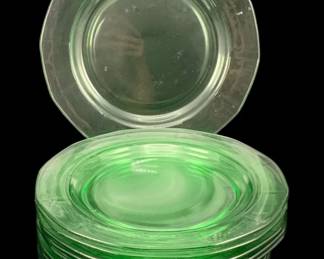 344 - 12 Uranium Green Glass Plates 7.5" (Description): A set of twelve uranium glass plates. Each  plate measures 7.5 inches round. The  translucent green glass exhibits the  characteristic glow of uranium glass.