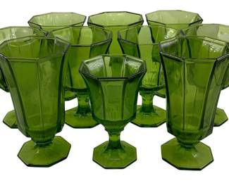 440 - 10 Green Glasses 6",7" tall (Description): A set of ten green glasses featuring an  octagonal paneled design on footed bases. The  glasses measure 6 to 7 inches tall.