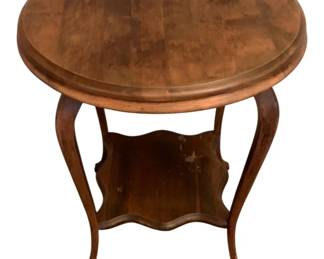 132 - Wood Parlor Table 30"x24" (Description): A wooden table featuring a round top  supported by four gracefully curved cabriole  legs. A shaped lower shelf connects the legs,  providing additional display or storage  space. Measures 30 inches in height by 24 inches in diameter.