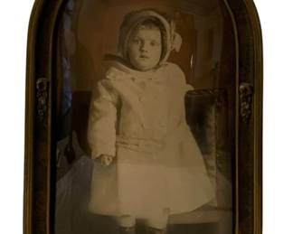 734 - Antique Framed Print 22"x14" (Description): Antique framed print featuring a portrait  photograph. The frame has a distinctive  arched top with decorative floral accents and  convex glass. Measures 22 inches by 14  inches.