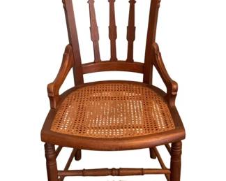159 - Antique Chair 35.5"x19"x18.5" (Description): Antique wooden chair featuring a decorative  carved crest rail, spindle back, and cane  seat. The chair has curved arms and turned  legs with stretchers. Measures 35.5 inches  high by 19 inches wide by 18.5 inches deep.