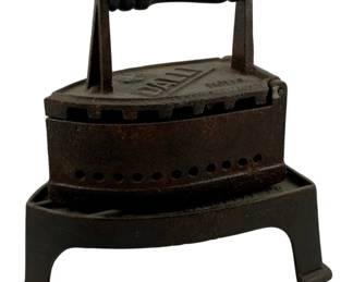 437 - Antique Galli Iron w/ Trivet Stand (Description): Antique Galli iron with trivet stand. This  cast iron pressing iron features a wooden  handle and rests on its original matching  trivet stand. Measures 11 inches by 9.5  inches by 6.25 inches.