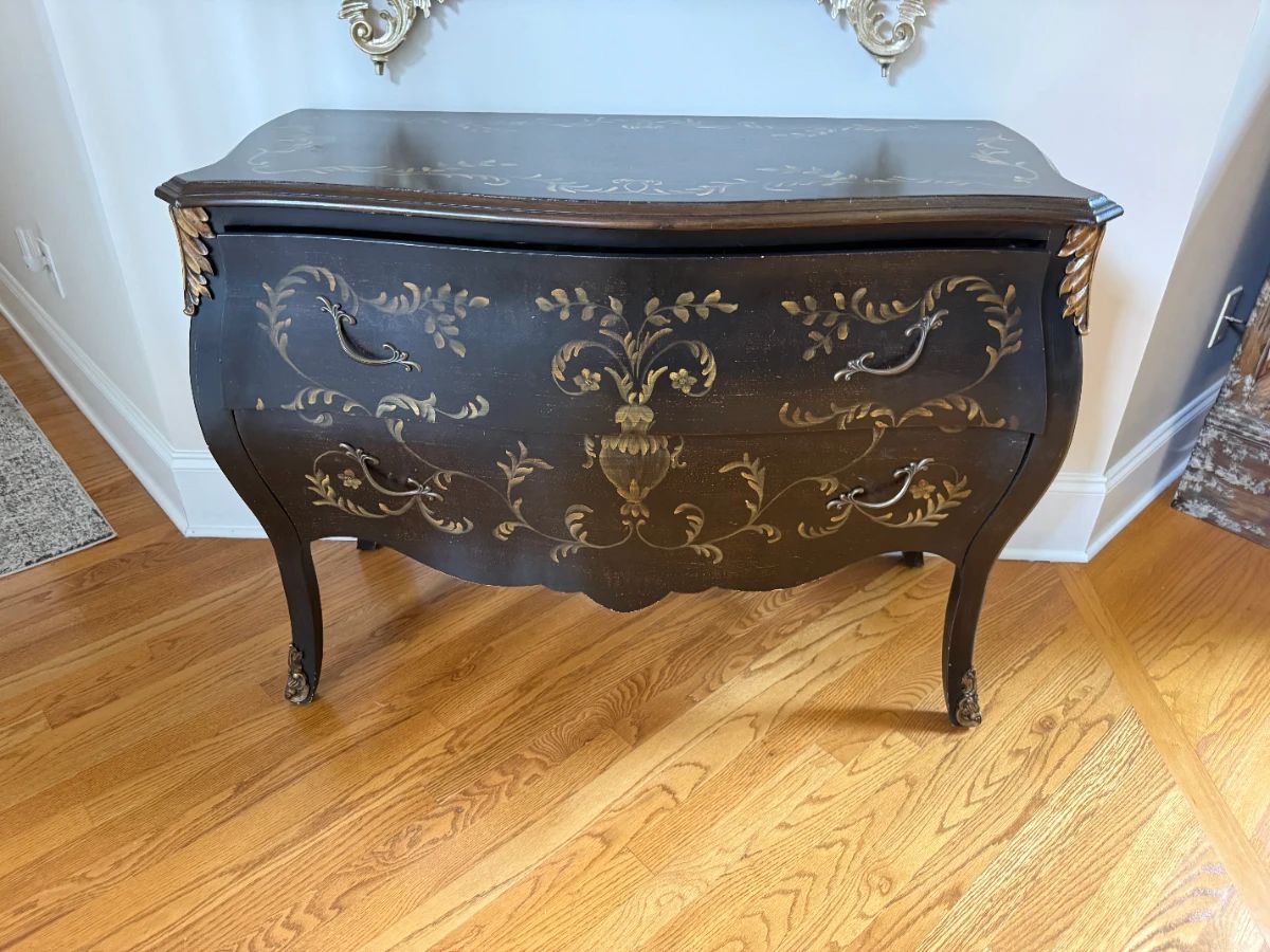 Louis XV or XVI style Black and Gold painted floral Bombe cabinet with ornate gilt scrolling details.