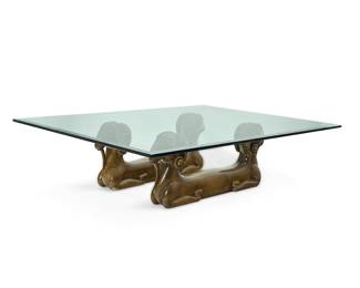 136 A Modern carved wood and glass figural coffee table Circa 1975 The beveled edge glass top over a base in the form of two pairs of conjoined rams 3 pieces Glass length, 68 1/4 in., width 48 1/4 in.; each ram height 16 in., length 40 in., depth 6 1/2 in. Estimate: $500 - $700