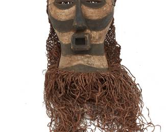 166 An African Kifwebe carved wood mask 20th century, Luba or Songye; Democratic Republic of the Congo Pigmented wood with applied woven fibrous backing and fringe Overall height 26 in., width 15 in., depth 7 1/2 in. approximately Estimate: $300 - $500