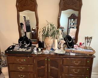 Large double dresser with mirrors loaded with jewelry.