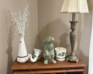 An array of Hull pottery underneath and beside an inquisitive bunny